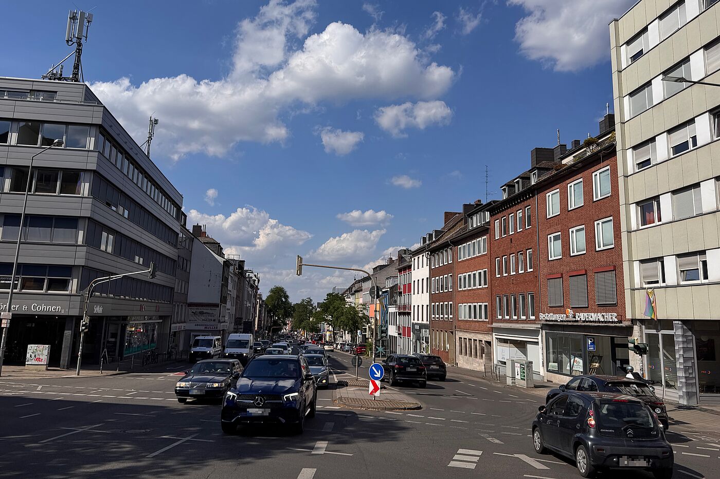 Wilhelmstraße an der Normaluhr Blick auf eine große Kreuzung an der Wilhelmstraße in Aachen mit vielen Autos, Ampeln, Mittelinsel und breiter Fahrbahn. Radverkehrsanlagen sind nur untergeordnet erkennbar.