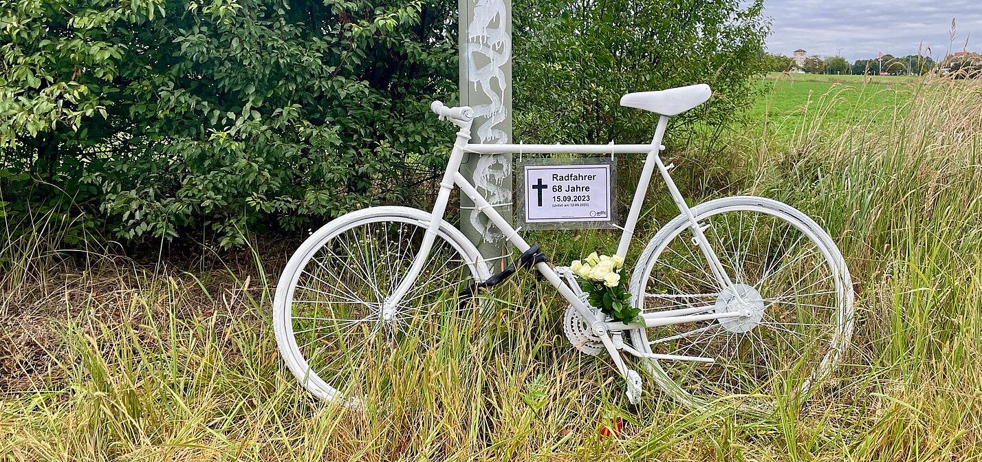 Geisterrad 22. September 2023 weißes Geisterrad mit Schild und weißen Rosen am Wegrand