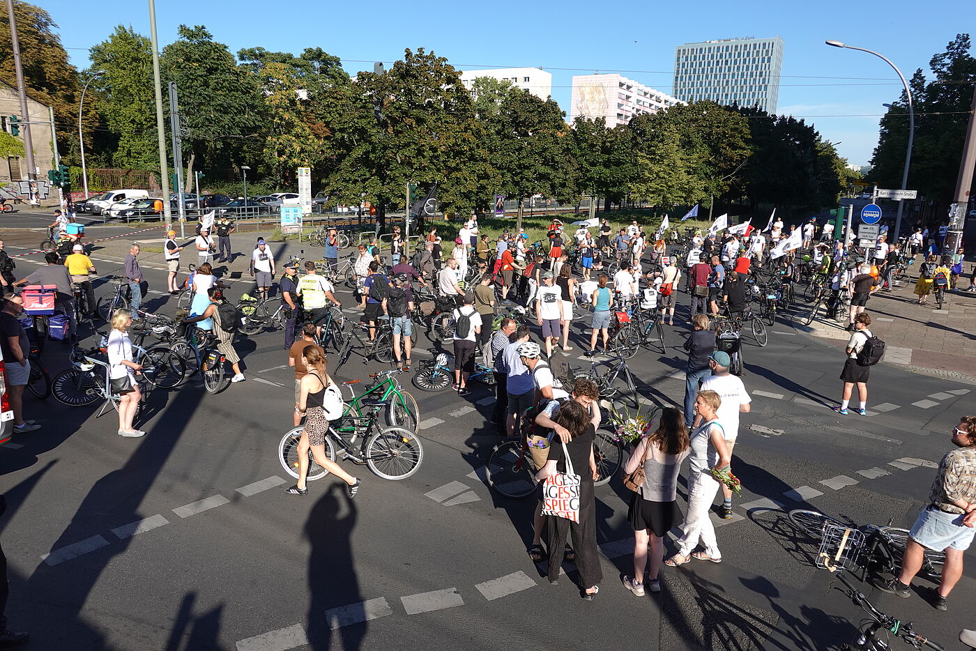 Menschen stehen für eine Mahnwache auf einer Kreuzung
