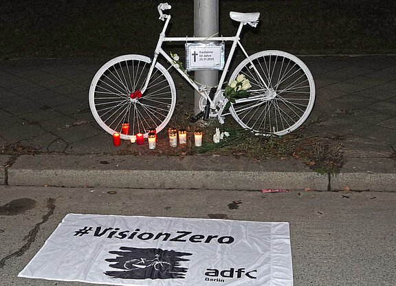 Geisterrad 1.12.2025 Tempelhof Ein weißes Geisterrad davor eine weiße Vision Zero Fahne
