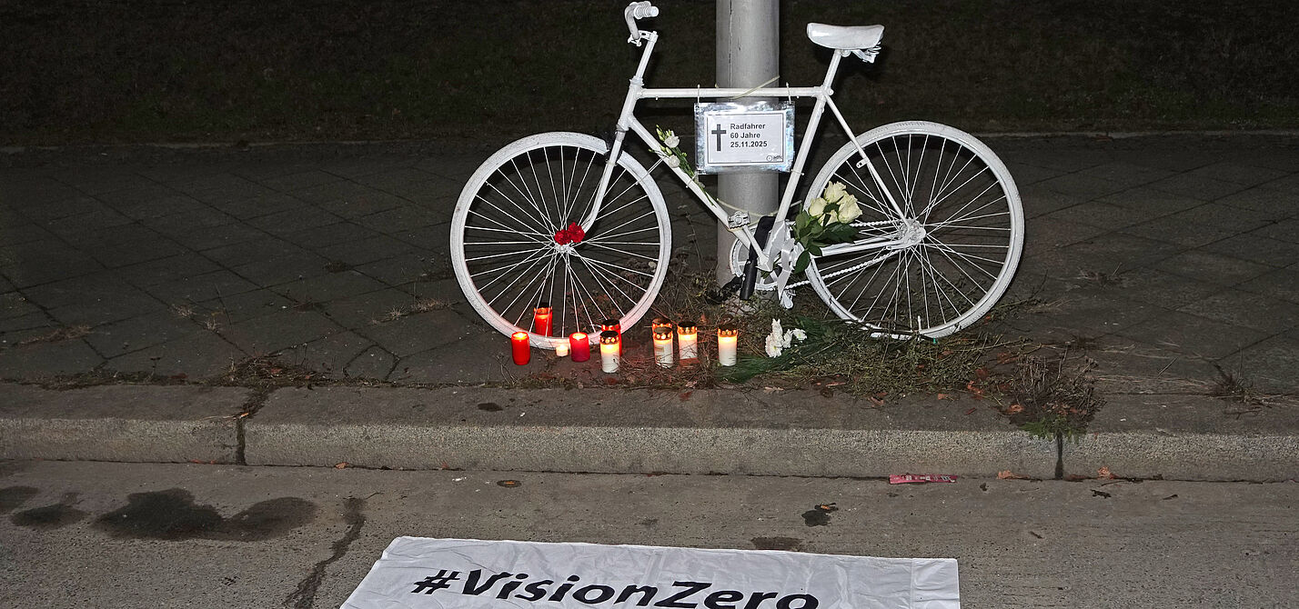 Geisterrad 1.12.2025 Tempelhof Ein weißes Geisterrad davor eine weiße Vision Zero Fahne