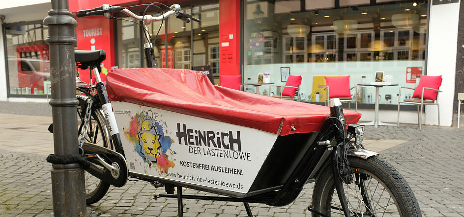 Lastenlöwe Das Bild zeigt ein Lastenfahrrad mit dem Aufdruck: Heinrich der Lastenlöwe - kostenfrei ausleihen