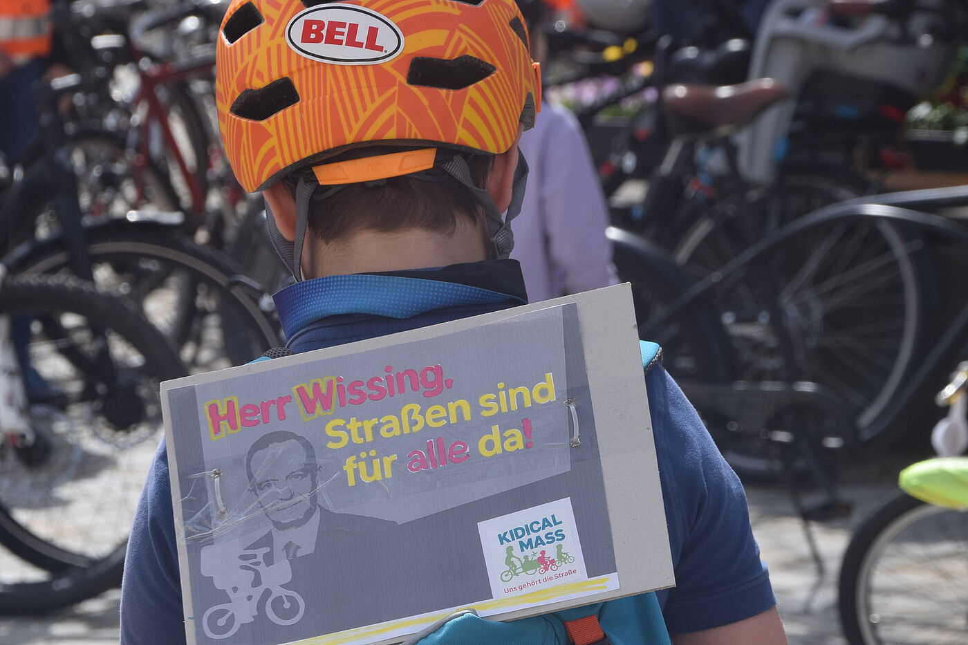 Junger Demonstrant Kind mit Fahrradhelm, Rucksack und Demoplakat