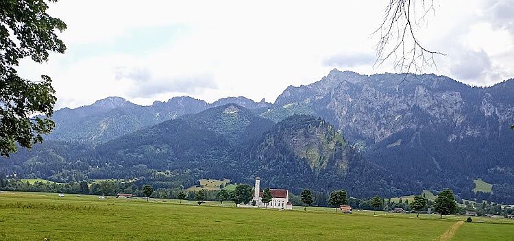 Alpenpanorama Kirche im Feld mit Bergen im Hintergrund