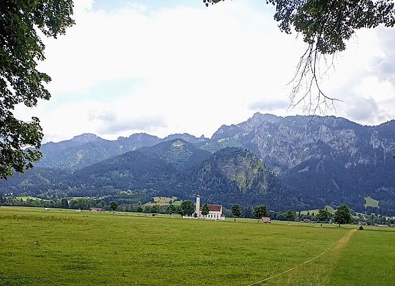 Alpenpanorama Kirche im Feld mit Bergen im Hintergrund