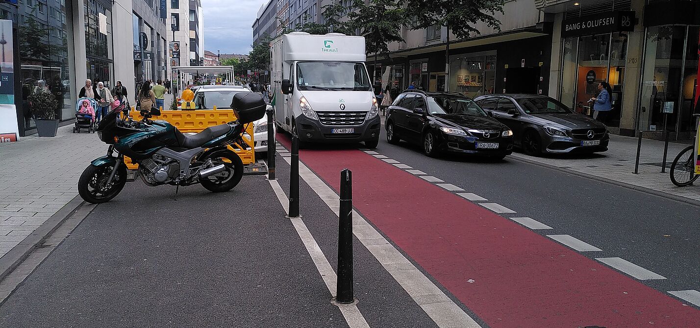 Fressgasse im Mai 2024 Das Bild zeigt die Fressgasse, mit einem parkenden Lieferwagen auf der Radspur
