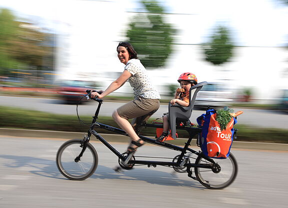 Frau mit Kind und Einkauf auf Lastenrad Frau mit Kind und Einkauf auf Lastenrad