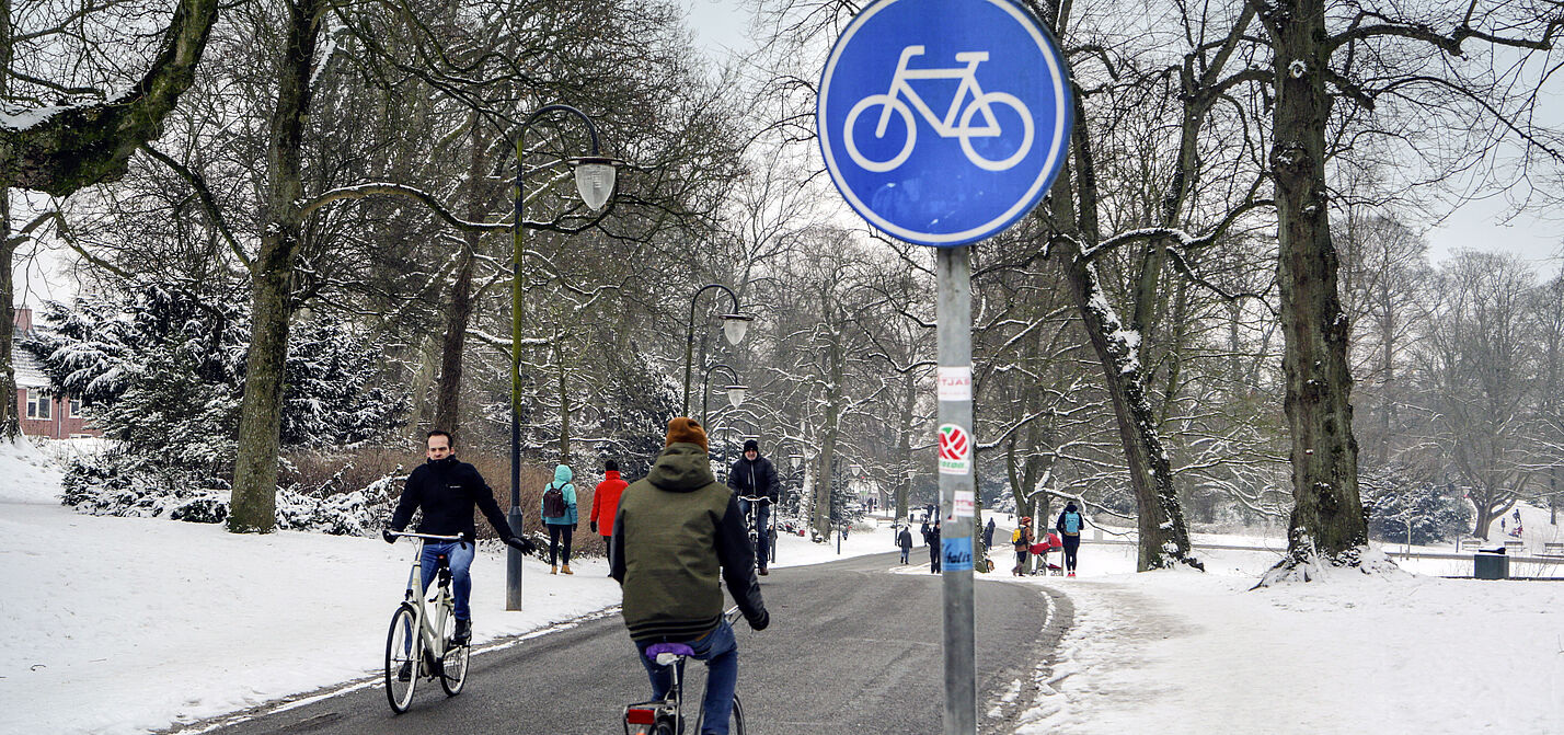 Winterlicher Fahrradweg in Groningen Radfahrer auf geräumten Radweg in Groningen