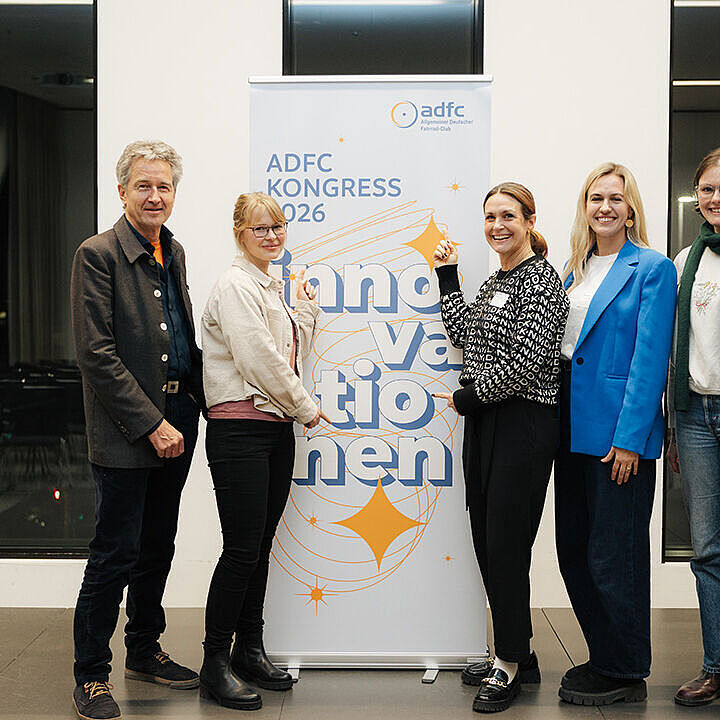 Fünf Personen stehen nebeneinander und posieren vor einem Roll Up zum ADFC Kongress 2026.