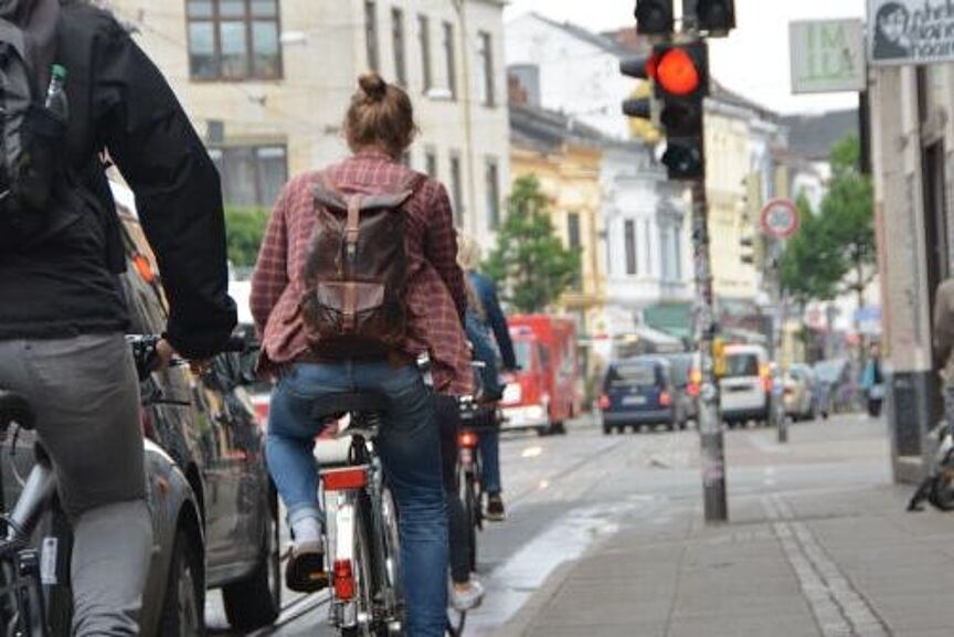 Fahrradkommunalkonferenz 2020 Radfahrende fahren auf schmelaem Bürgersteigradweg neben parkenden Autos.