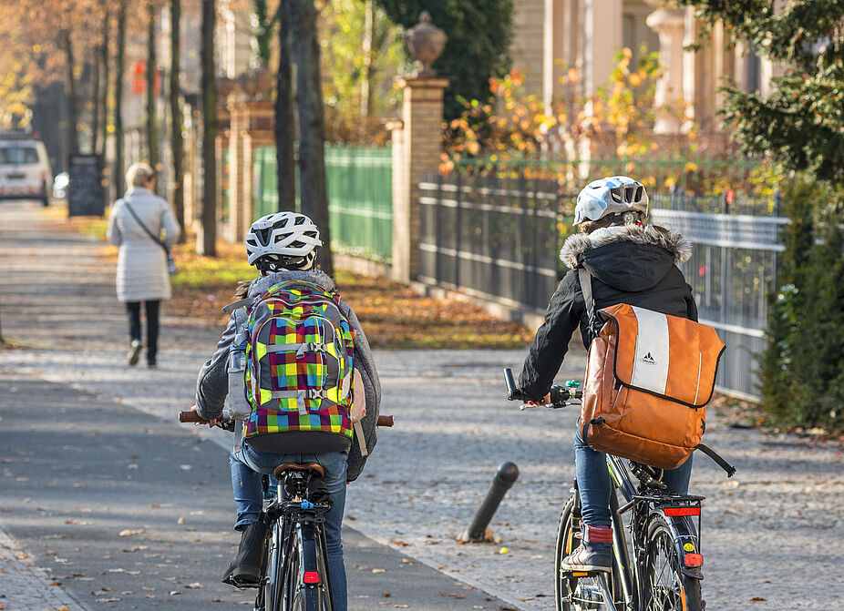 Kinder auf dem Fahrrad unterwegs Zwei Kinder auf ihren Rädern auf einem Radweg