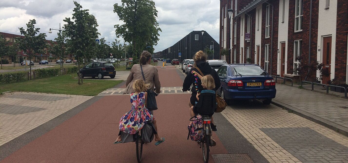 Separierte Radwege in den Niederlanden laden alle zum Radfahren ein Zwei Frauen mit Kinder auf dem Rad auf einem breiten, separierte Radweg in den Niederlanden