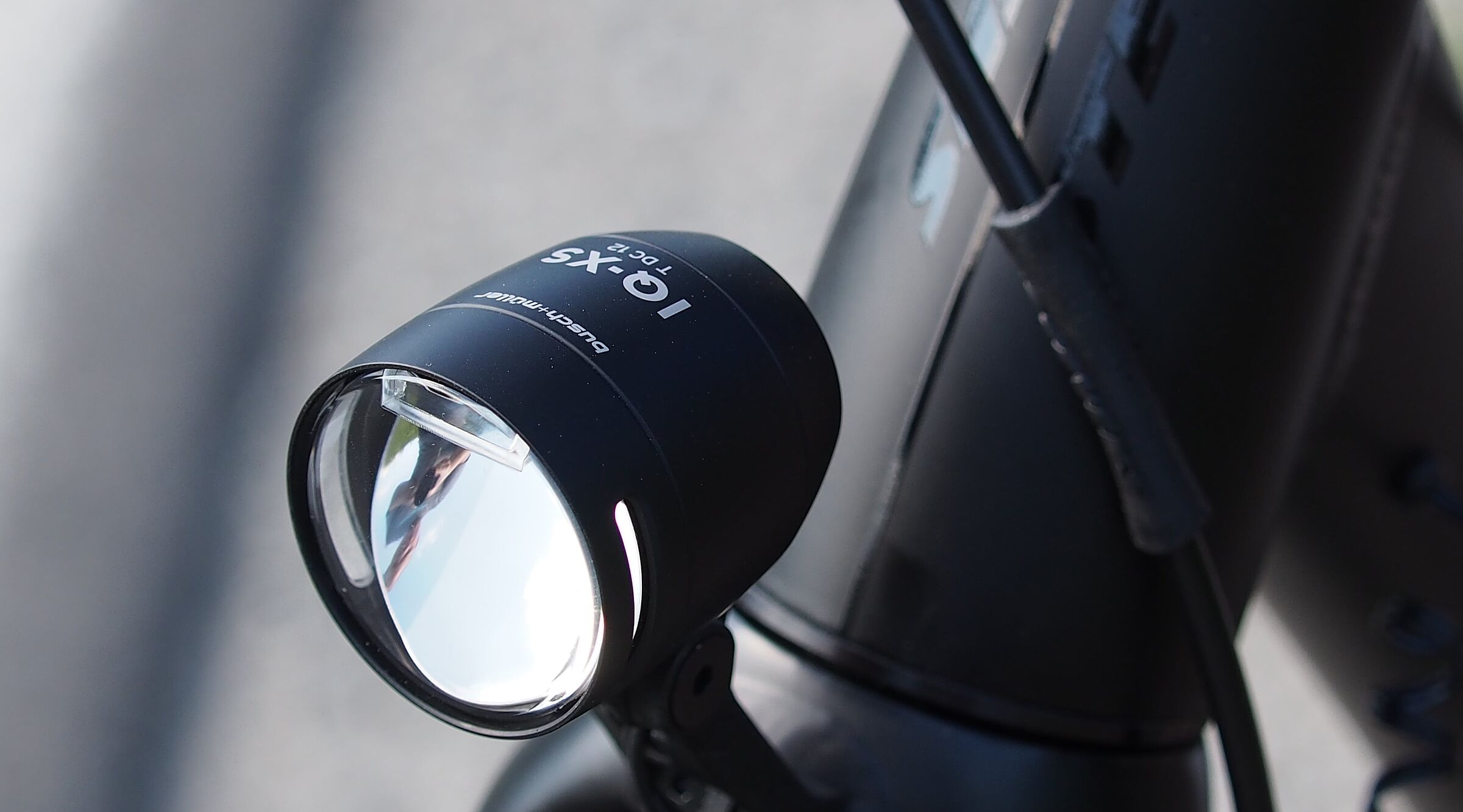 Schwarzer LED-Fahrradscheinwerfer am silbernen Fahrradlenker montiert.