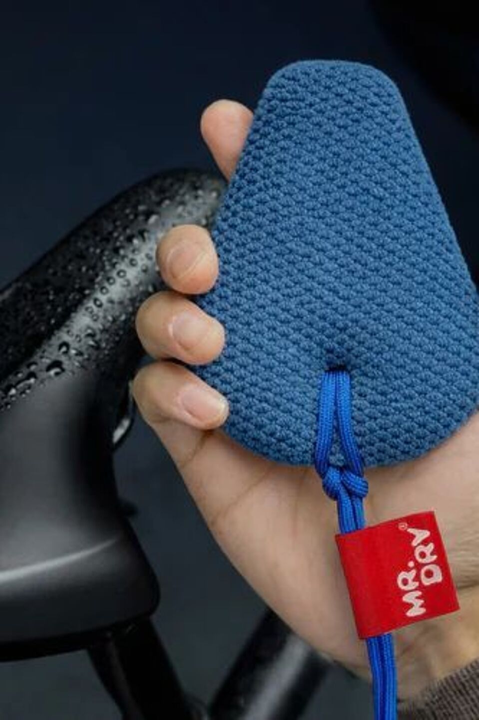 Mr. Dry 1 Eine Hand hält einen kleinen blauen Schwamm.