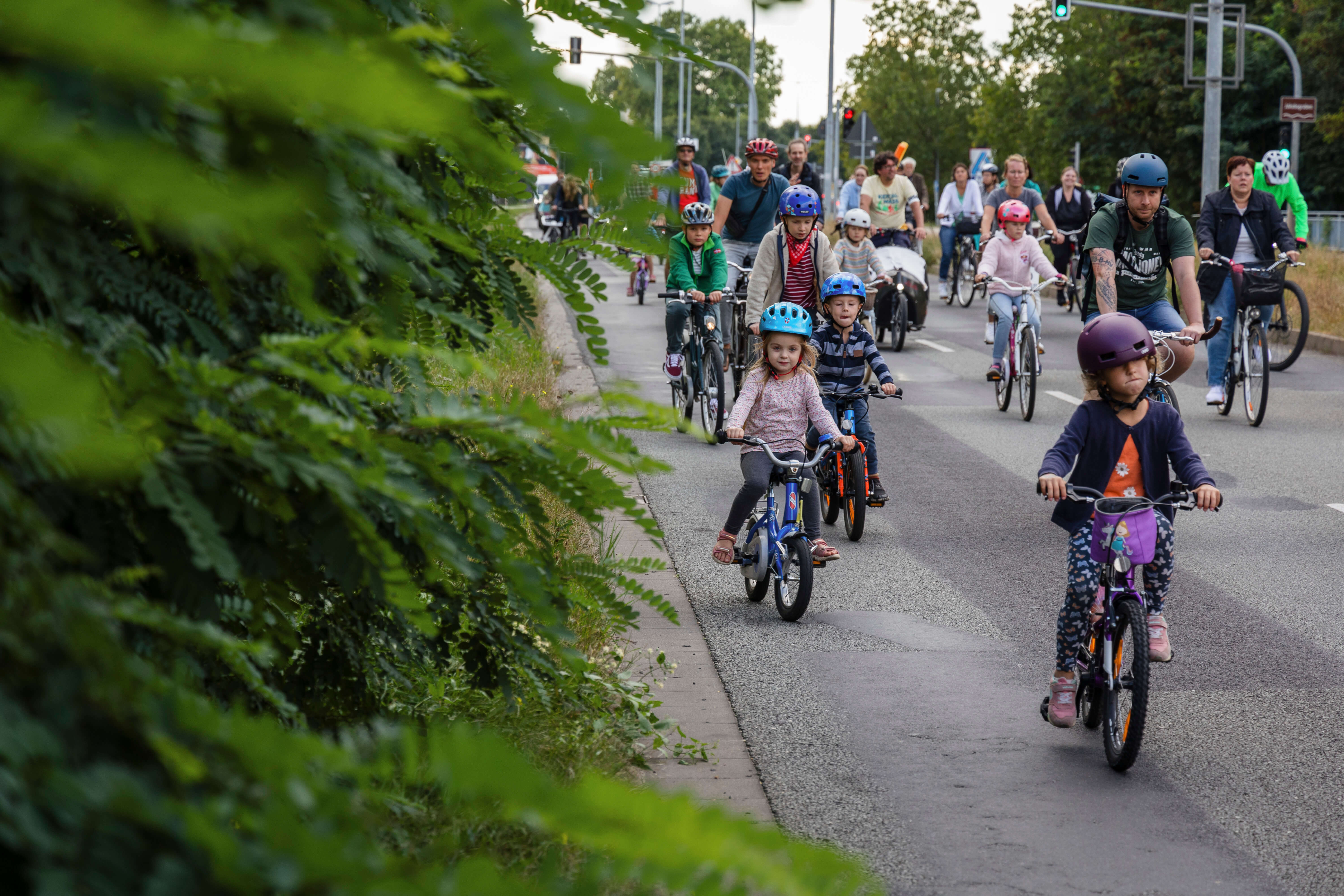 Kinder unterschiedlichen Alters und Erwachsene demonstrieren auf der Straße mit ihren Fahrrädern.