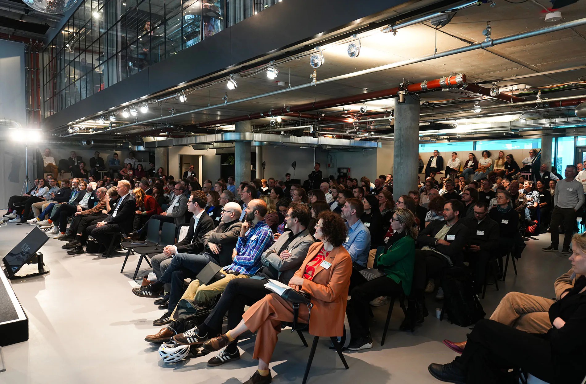 Ein Saal voller Menschen, die an der DB-Konferenz Anschluss erreichen teilnehmen.