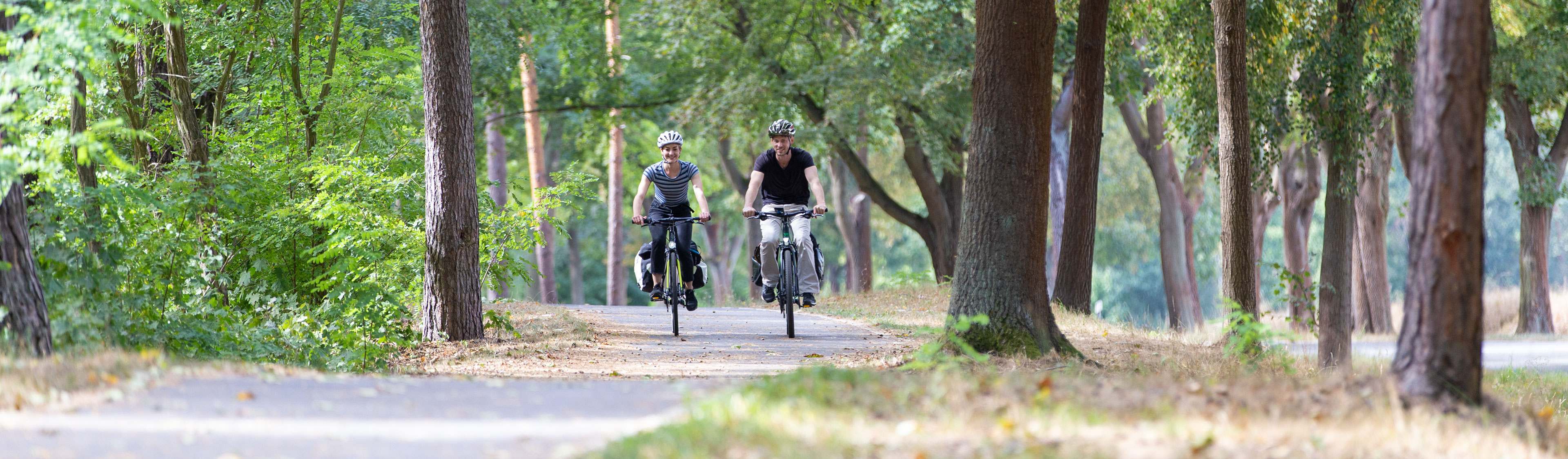 Zwei Radfahrende auf ländlichem Radweg