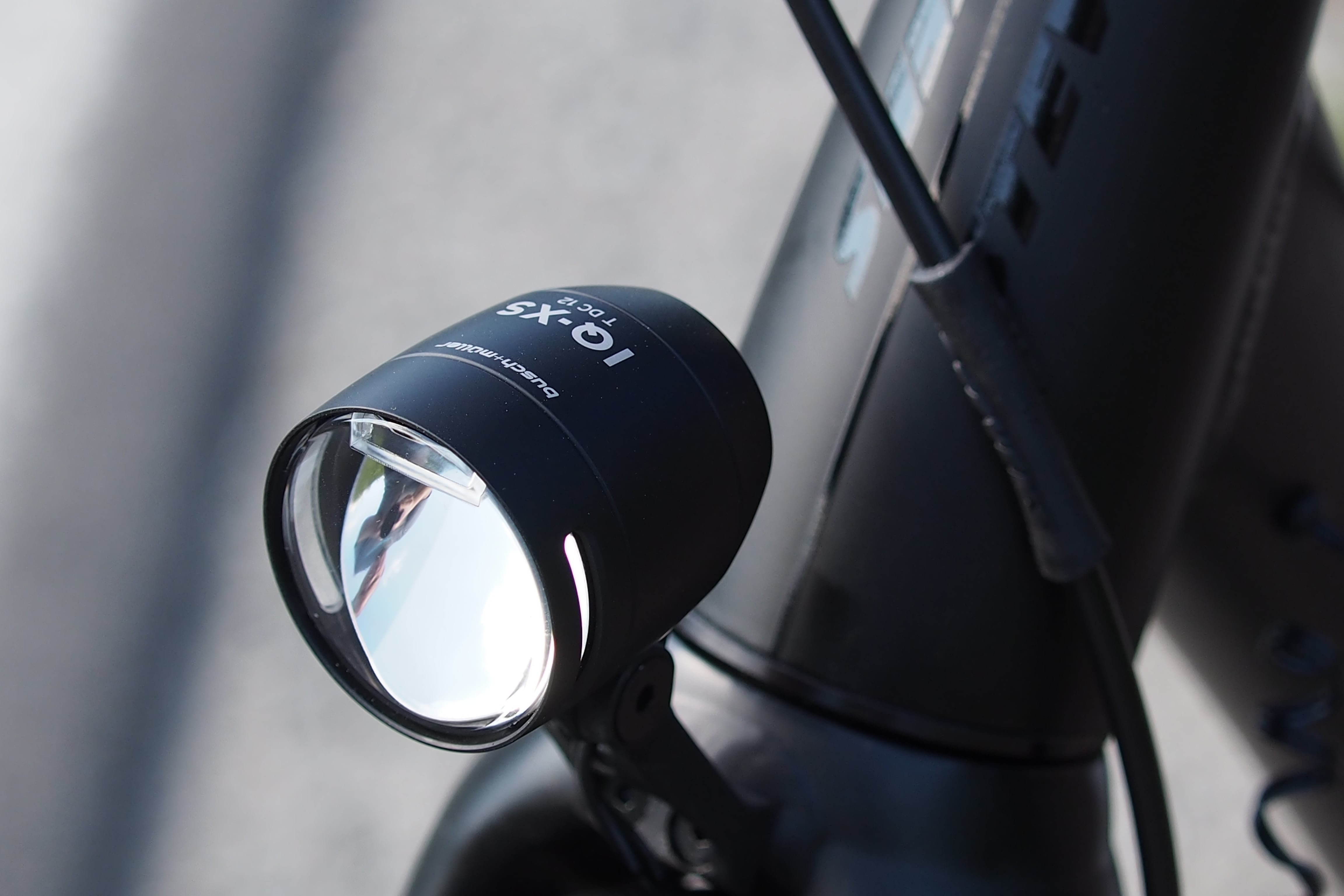 Schwarzer LED-Fahrradscheinwerfer am silbernen Fahrradlenker montiert.