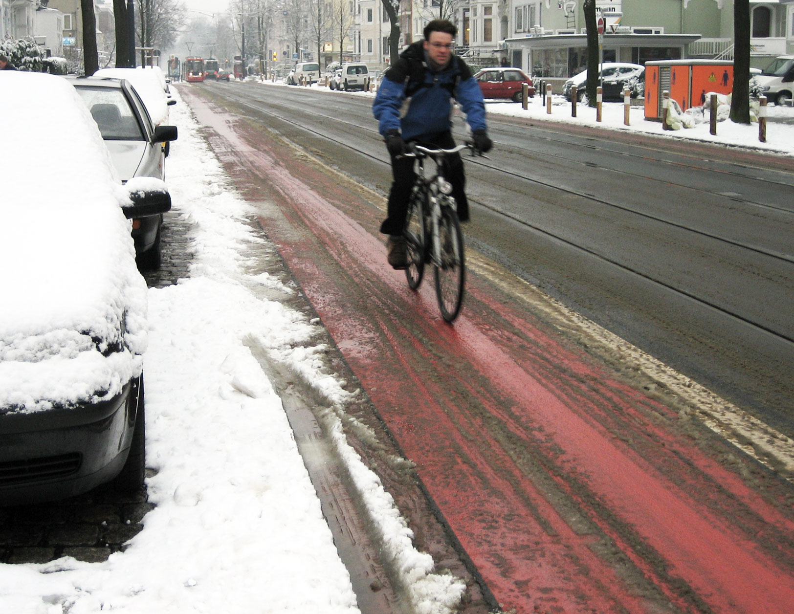 Ein leicht verschneiter Radweg.