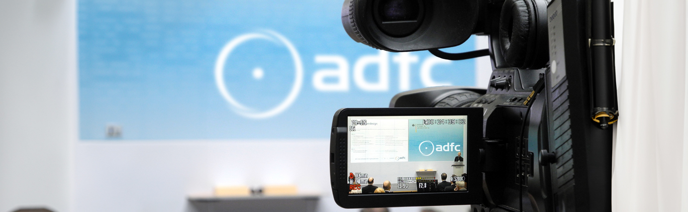 Videokamera im Vordergrund zeigt auf ihrem Display eine Präsentation mit dem ADFC-Logo